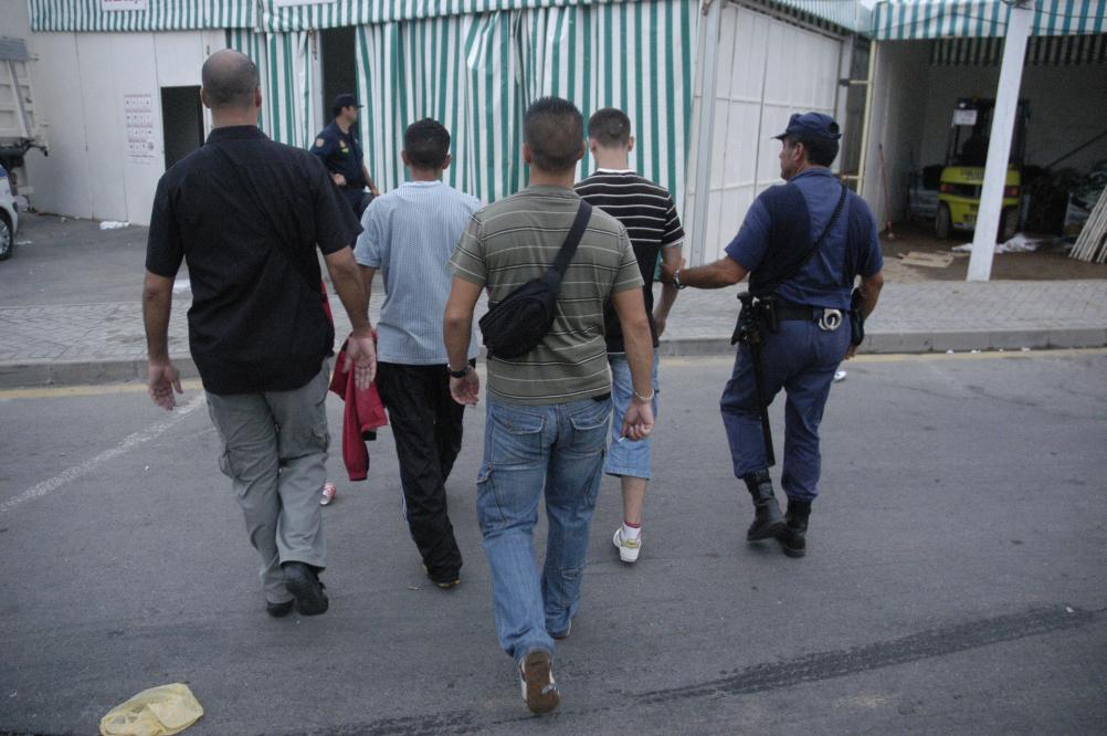 Policías Nacionales custodiando a detenidos en el recinto ferial