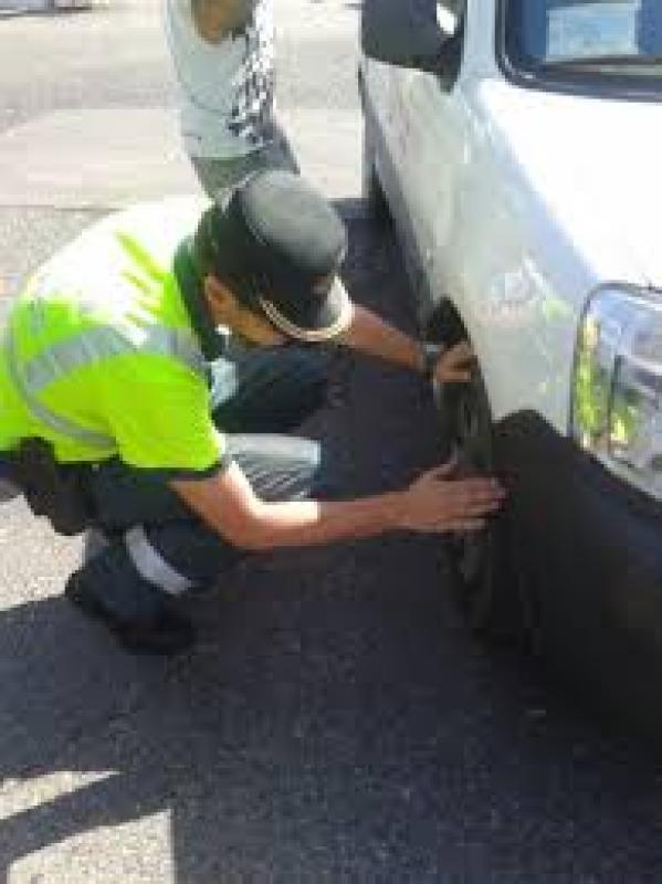 Un agente inspecciona los neumáticos de un vehículo