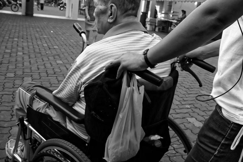 Cuidador de una persona en silla de ruedas