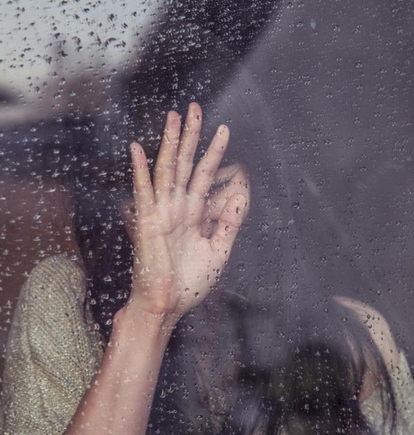 Mujer llorando tras una ventana